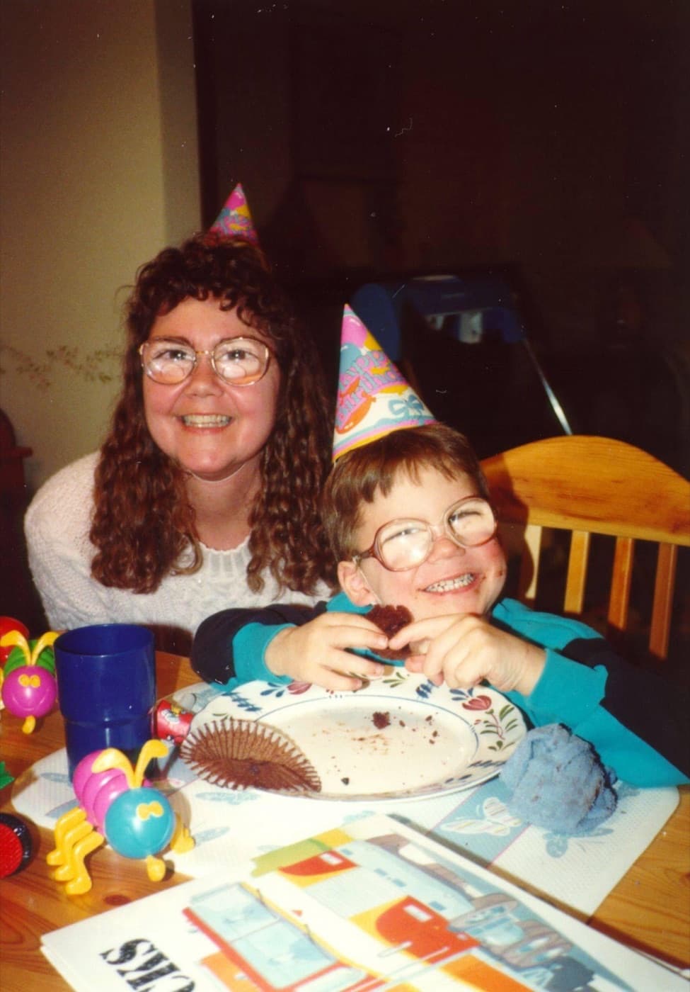 Kathleen and her son Brian wearing party hats at a birthday table